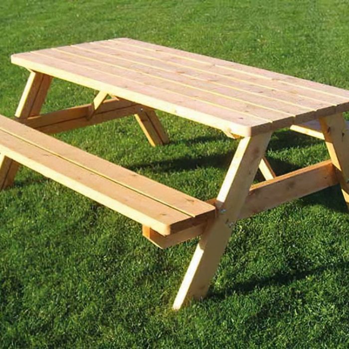 Bänkbord ståendes i gräset vid en rastplats.