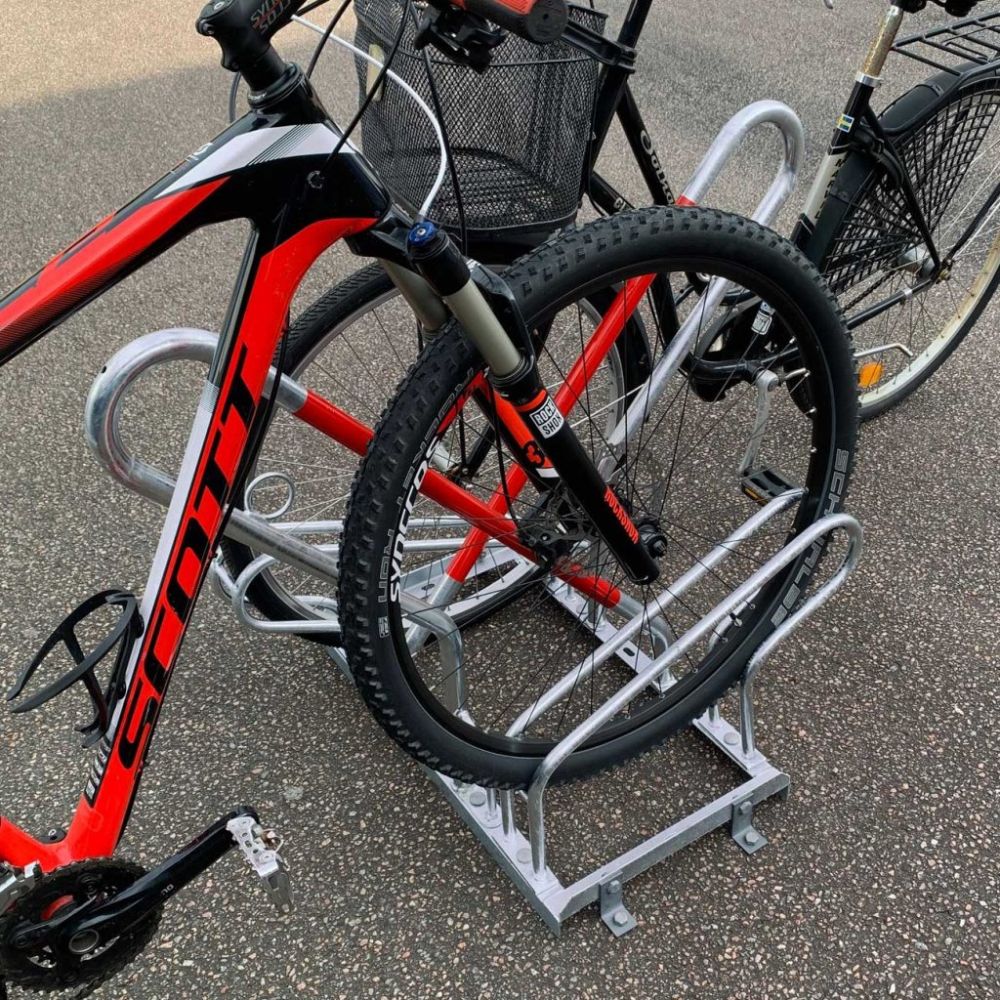 Ett cykelställ med ramlås. En röd cykel MTB står fastlåst i ramlåset.